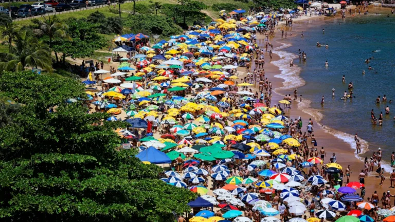 Vista aérea da Praia da Bacutia cheia de guarda-sóis, em Guarapari